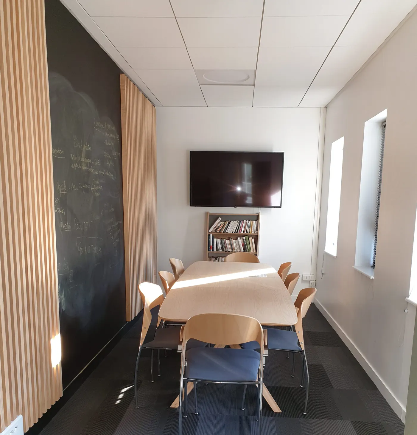 Salle de formation avec écran mural et table en U